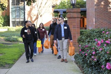 A student leads a tour group on campus