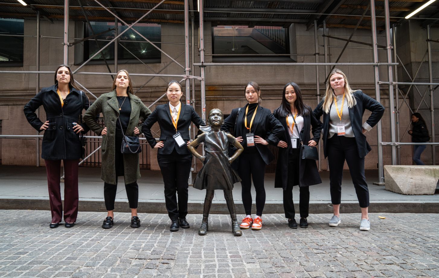 students pose with the fearless girl statue