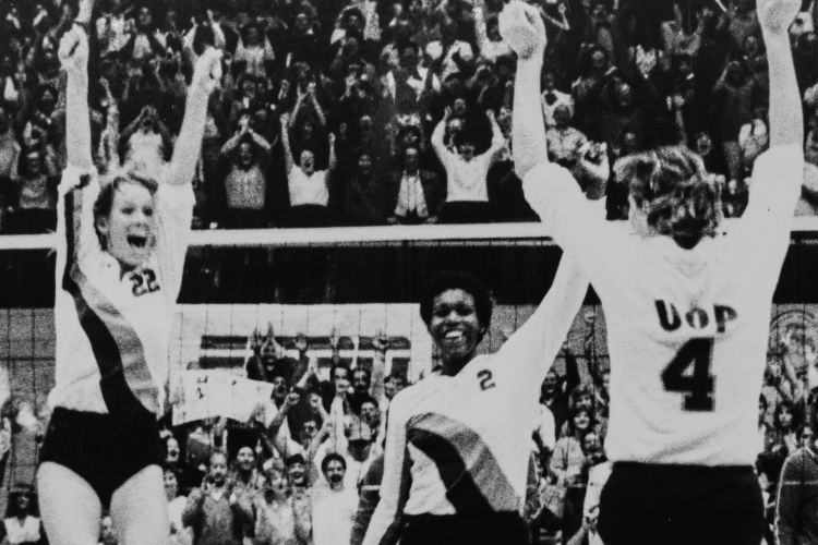 Volleyball players celebrate a win on the court