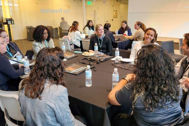 students sit at a table inside Bloomberg's offices