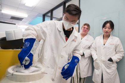 three students in white lab coats