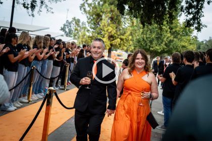 a couple walks the orange carpet at the Orange and Black ball
